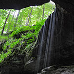 Image of a small waterfall at the edge of a cave entrance. Source: Department of the Interior